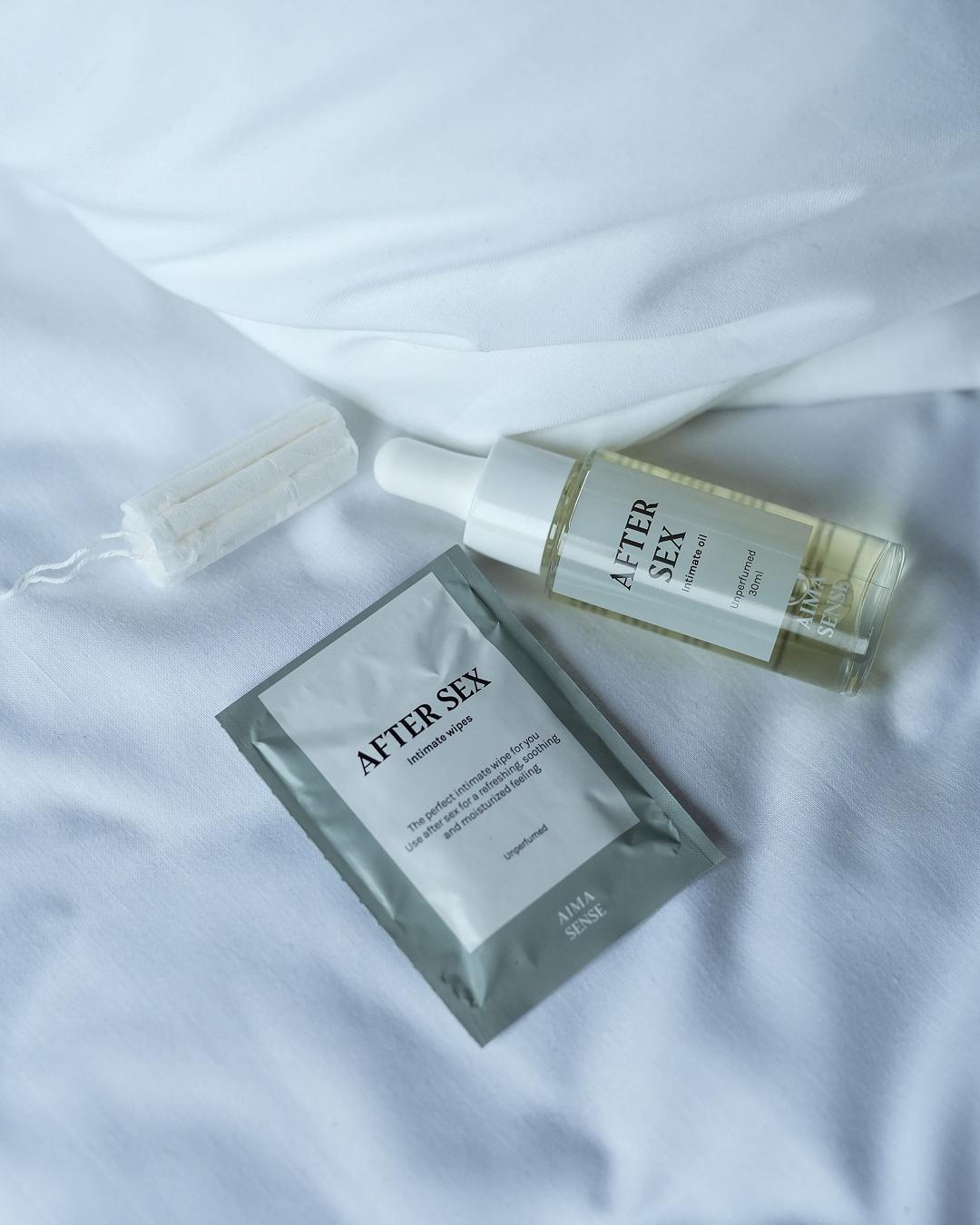 Aima Sense After Sex kit med intimservett, olja och tampong på vit bädd